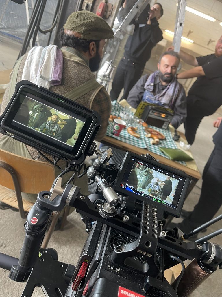 Behind the scenes: RED camera with the tea scene on the monitor, the actor behind it