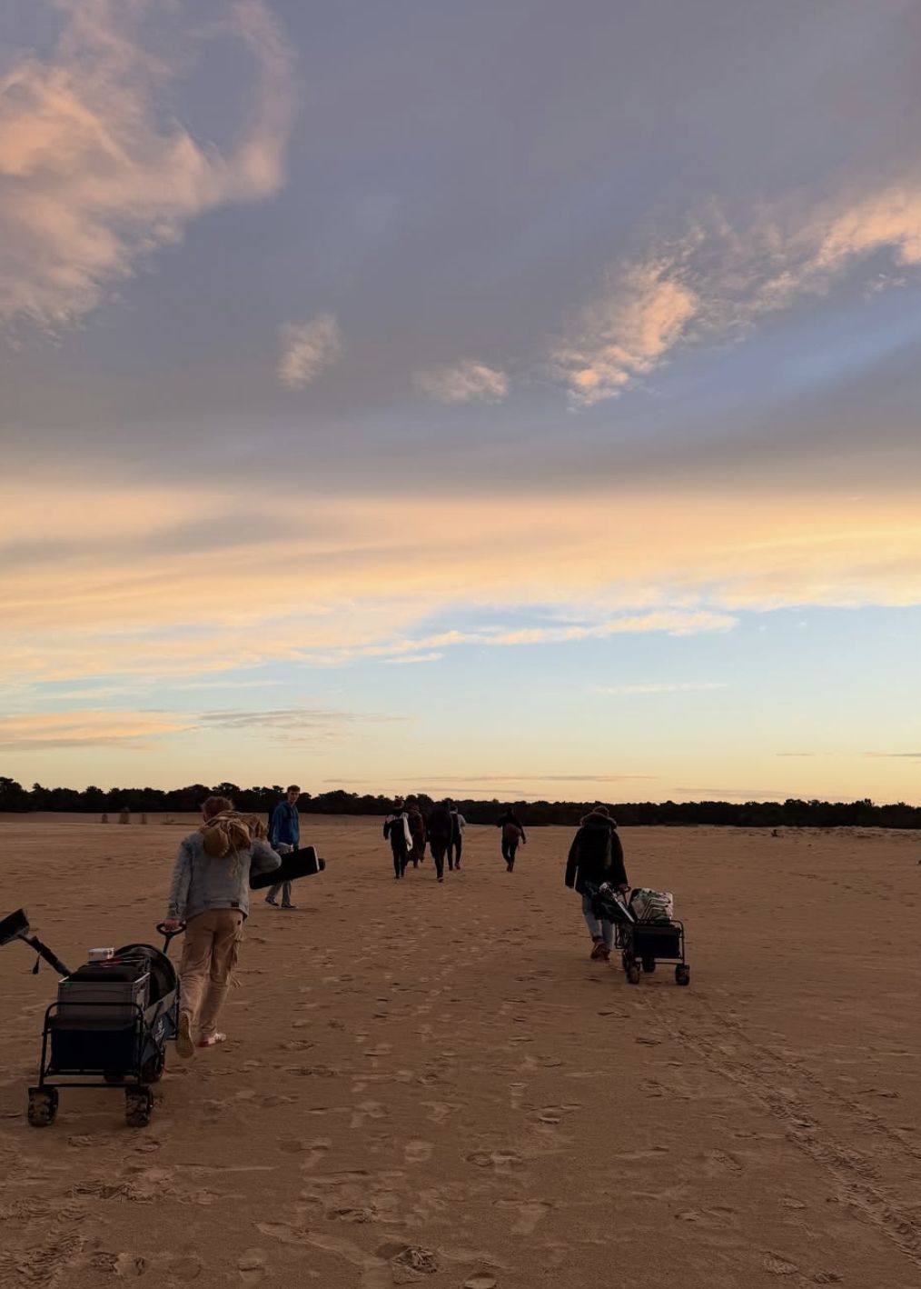 Behind the scenes: The crew pulls gear across the sand at sunset