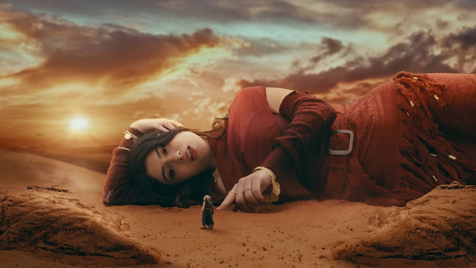 A giant woman lies in the desert at sunset