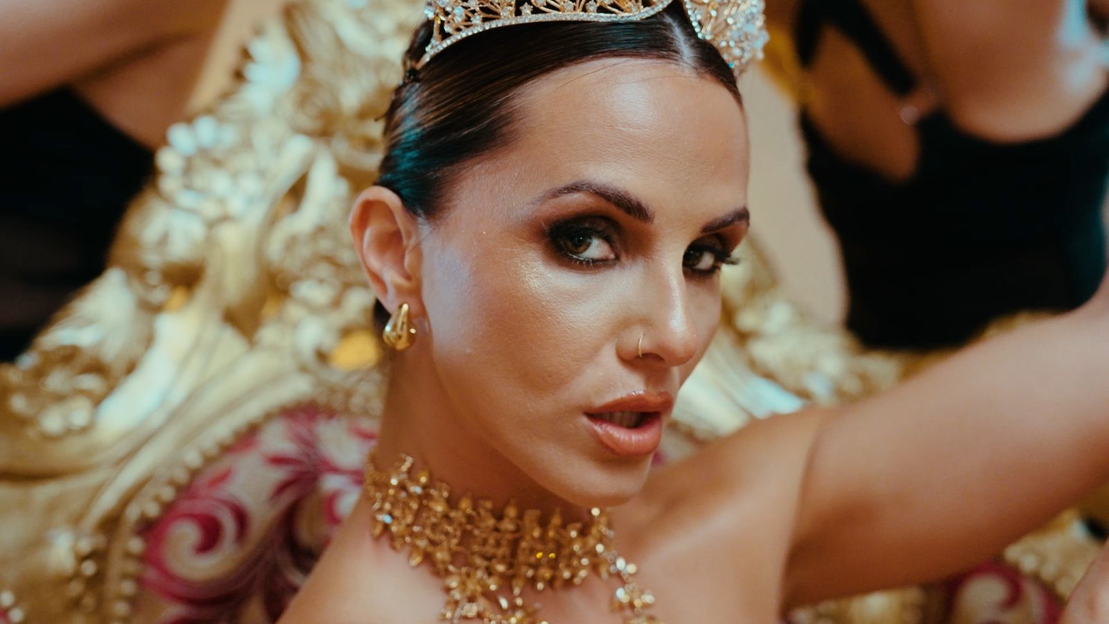 Close-up of Julia wearing a crown and gold jewellery