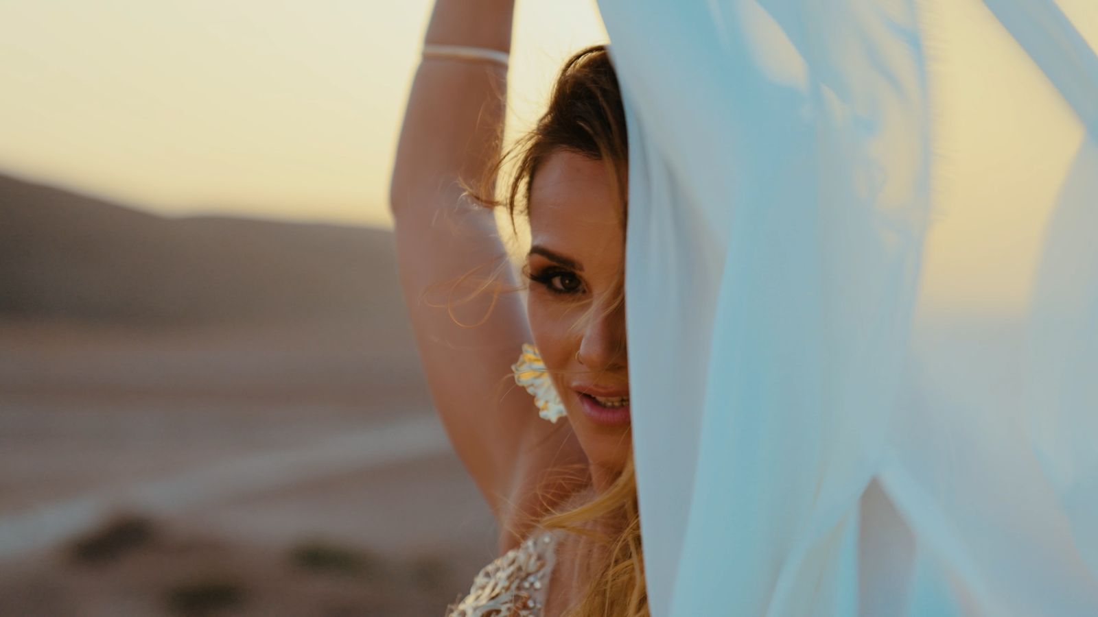 Julia half hidden behind white fabric in the wind